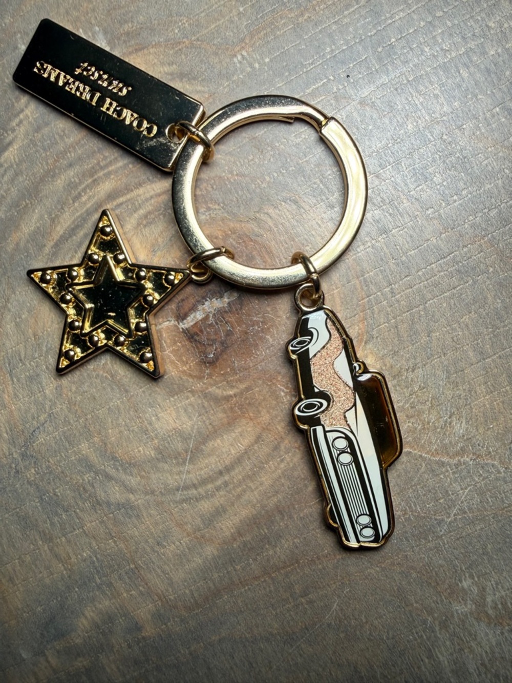 Coach Dreams Sunset gold-tone keychain featuring convertible car and star